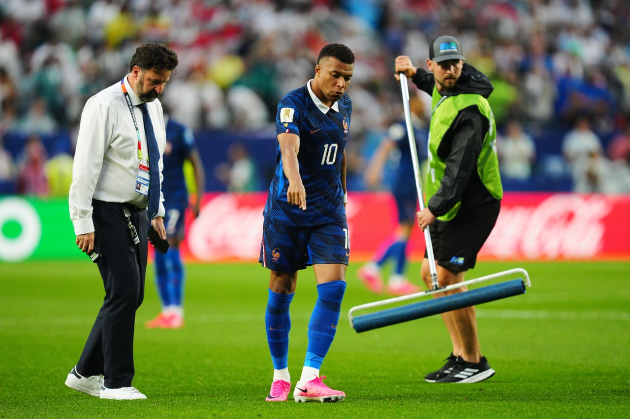 El francés Kylian Mbappé (10) indica al personal de mantenimiento dónde retirar el agua del campo tras una interrupción por mal tiempo en el partido de fútbol del Grupo I de la Copa del Mundo entre Francia e Irak, en Filadelfia, el lunes 22 de junio de 2026.