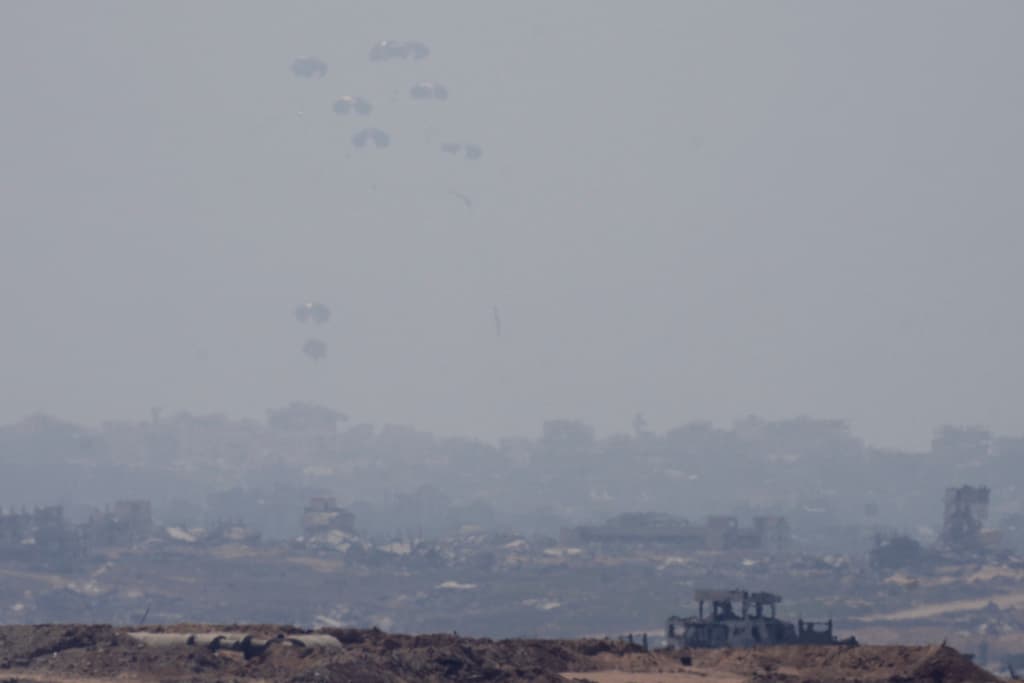 Ayuda humanitaria lanzada desde el aire sobre la ciudad de Gaza, vista este domingo desde el sur de Israel.