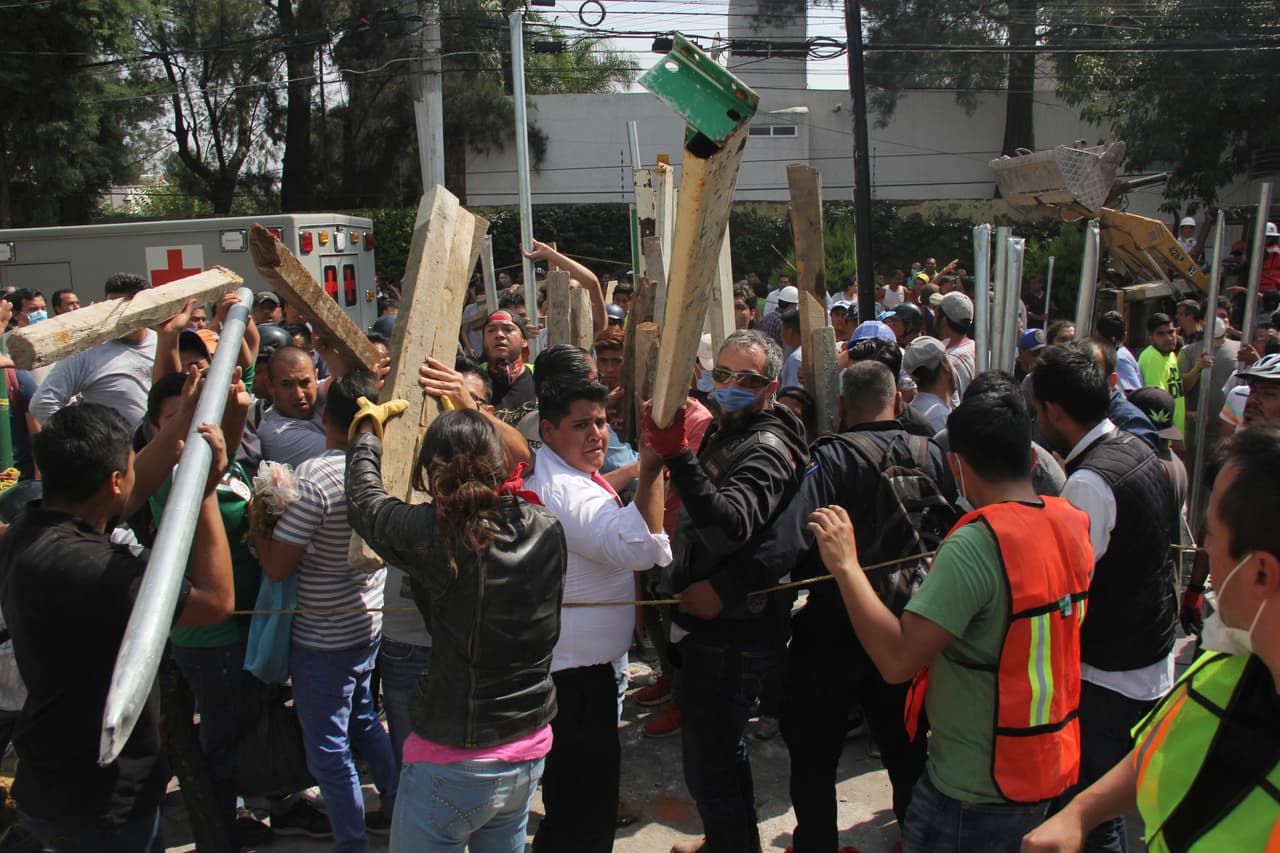 Varios voluntarios trasladan vigas de madera para ayudar a sostener secciones de la escuela derruida Enrique Rebsamen, mientras equipos de rescate buscan a niños atrapados dentro, en Ciudad de México, el martes 19 de septiembre de 2017. Un sismo de magnitud 7,1 golpeó el centro de Mëxico, matando a más de 100 personas y derribando edificios. (AP Foto/Carlos Cisneros)