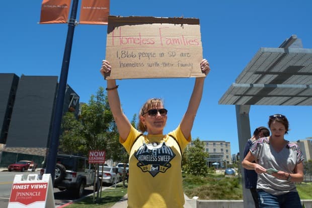 Próximo a la carpa de un mendigo en East Village, San Diego, una activista porta un pulóver en repudio a las “limpiezas” a raíz del Juego de las Estrellas.