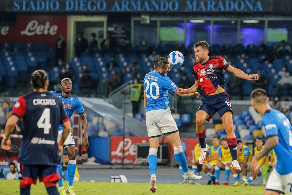 Napoli's Polish midfielder Piotr Zielinski (C) and Cagliari's Dutch midfielder Kevin Strootman go for a header during the Italian Serie A between Napoli and Cagliari on September 26, 2021 at the Diego-Maradona stadium in Naples. (Photo by Carlo Hermann / AFP) (Photo by CARLO HERMANN/AFP via Getty Images)