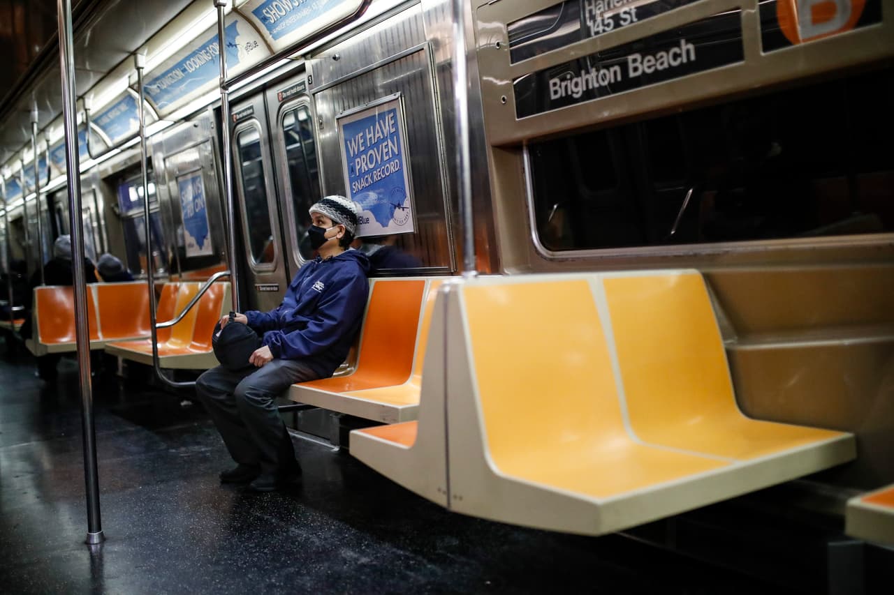 En esta foto de archivo del jueves 12 de marzo de 2020, un viajero usa una máscara facial mientras viajaba en un vagón del metro casi vacío hacia Brooklyn en Nueva York.