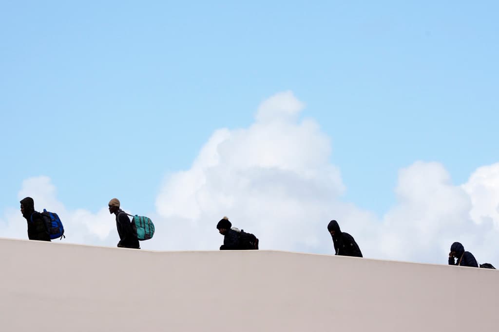 Personas cruzan a Estados Unidos para sus citas de CBP One con el fin de solicitar asilo en el país, el viernes 2 de febrero de 2024, en Tijuana, México. (Foto AP/Gregory Bull)