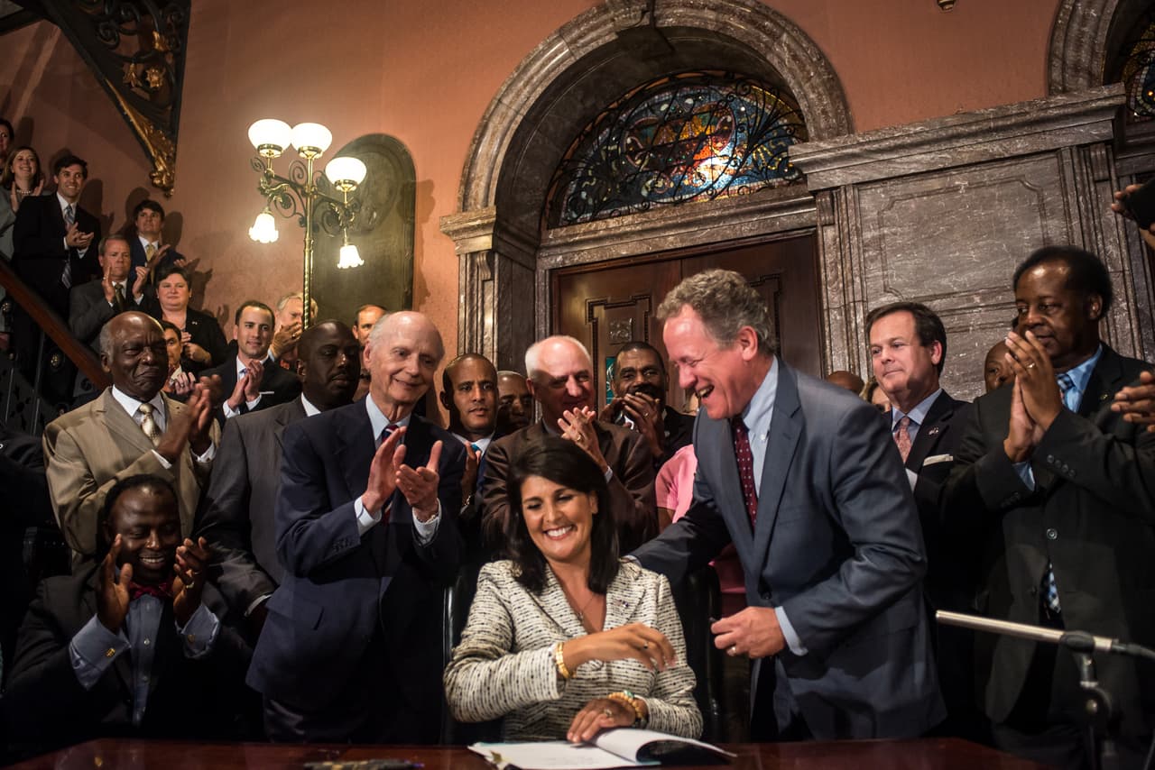 La gobernadora Nikki Haley firma un decreto que obliga a quitar la bandera confederada del parlamento de Carolina del Sur, luego de la matanza de afroamericanos en una iglesia de Charleston.