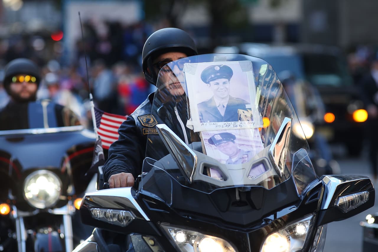 Con la foto de su padre, que combatió en la Segunda Guerra Mundial, y de otro oficial, este motorista desfiló en su honor.