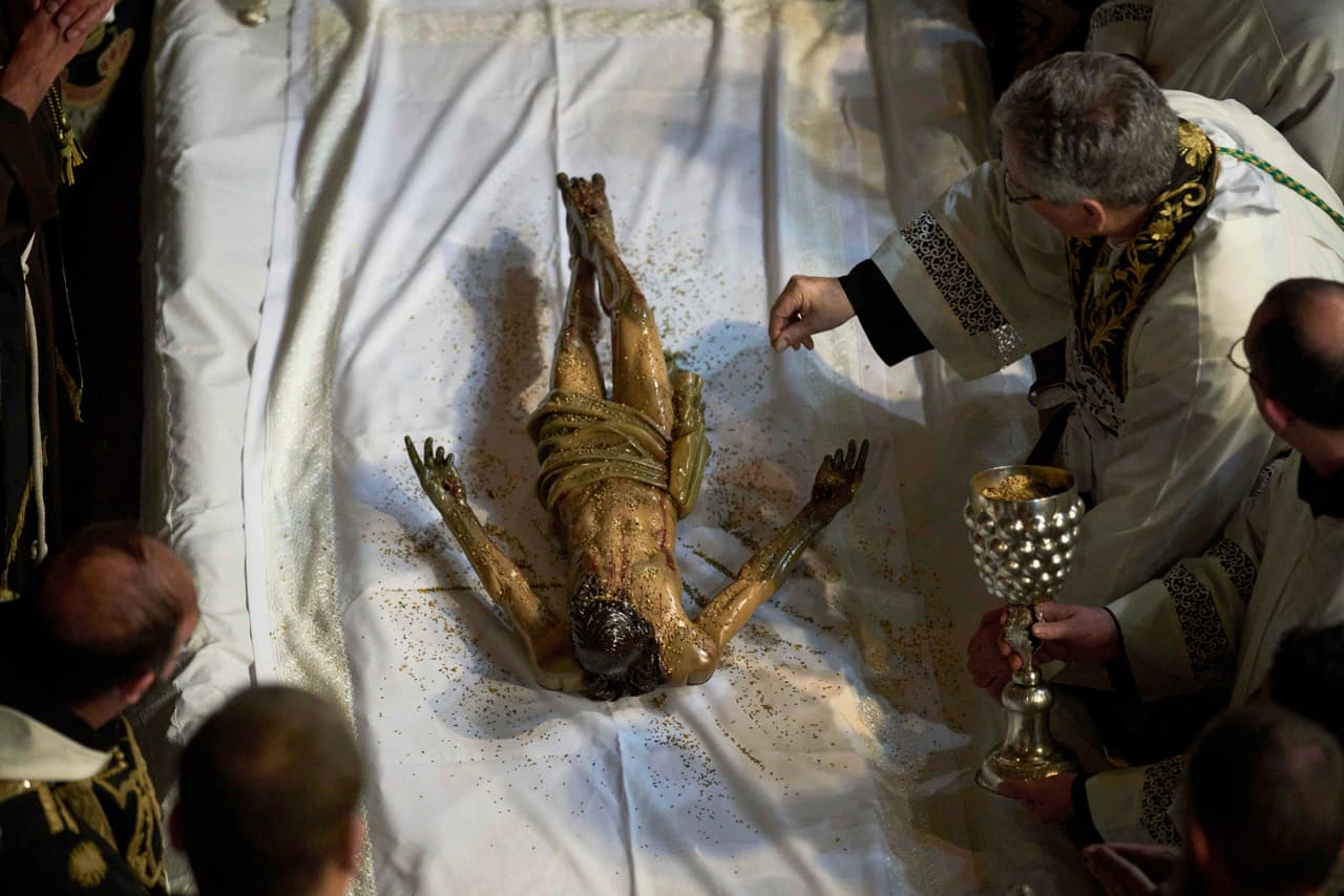Clérigos católicos participan en una ceremonia de Semana Santa que recrea el funeral de Jesucristo en la Iglesia del Santo Sepulcro, el lugar donde según la tradición fue crucificado y enterrado, en la Ciudad Vieja de Jerusalén, el viernes 18 de abril de 2025.