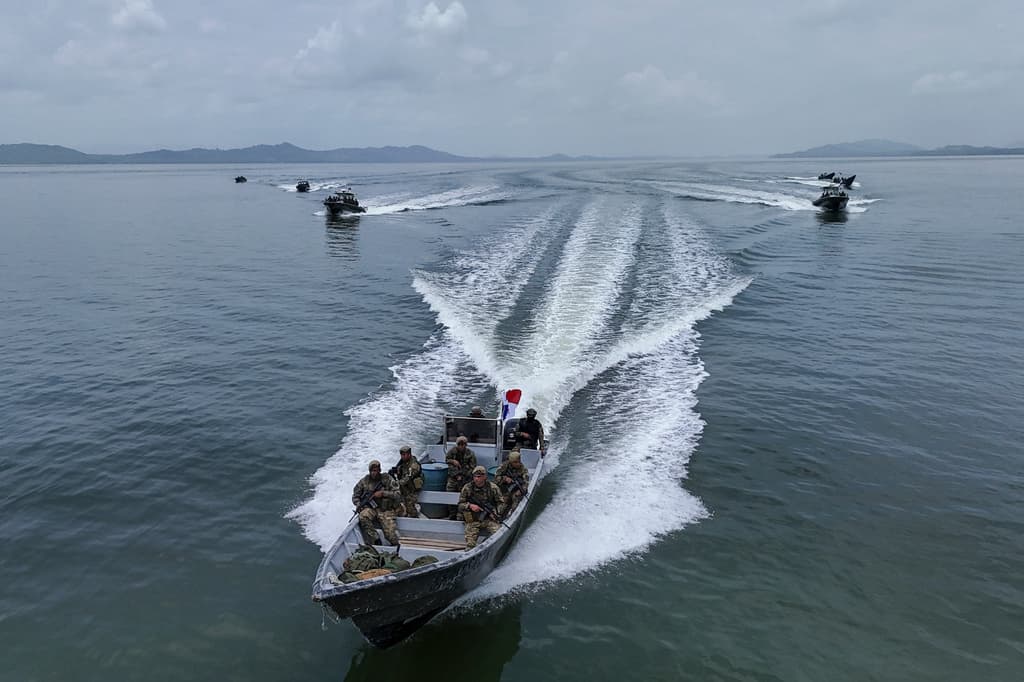 Policías fronterizos panameños navegan por la desembocadura del río Chucunaque mientras se despliegan para reforzar la seguridad a lo largo de la frontera con Colombia en La Palma, provincia de Darién, Panamá, el domingo 9 de agosto de 2026. (Foto AP/Matias Delacroix)