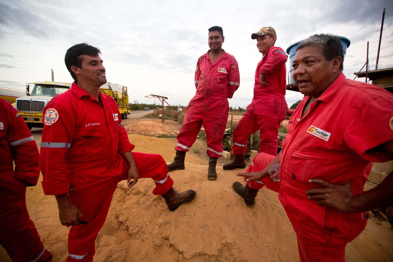 In this Feb. 18, 2015 photos, oil workers from PDVSA contractor Tucker Energy Services take a break from moving equipment to an oil field near El Tigre, a town located within Venezuela's Hugo Chavez oil belt, formally known as the Orinoco Belt. The workers said their company was asking them to ready as many six new wells a week. Now it's down to half that and they fear it could drop even more. (AP Photo/Fernando Llano)