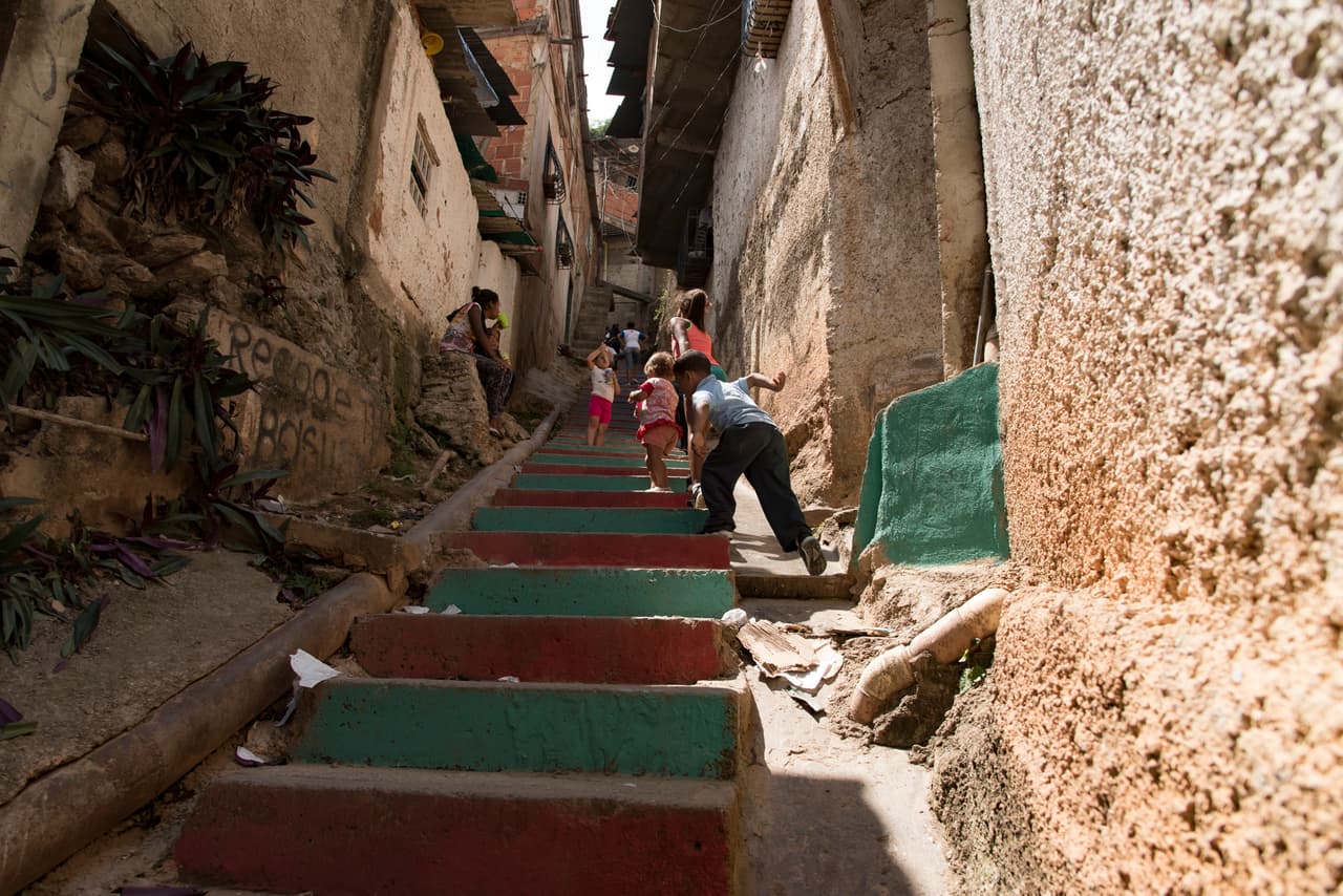 Un grupo de niños juega en una escalinata de La Vega, un barrio pobre de la capital de Venezuela, donde la mayoría de las personas vive en construcciones improvisadas. Allí fue instalado un comedor de Sustento, una iniciativa privada para dar comida a 7,500 niños en ocho estados del país.