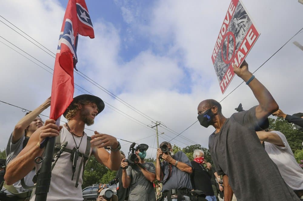 Varias docenas de manifestantes de derecha, algunos ondeando la bandera de batalla confederada y muchos con equipo militar, se reunieron en el centro de Stone Mountain.