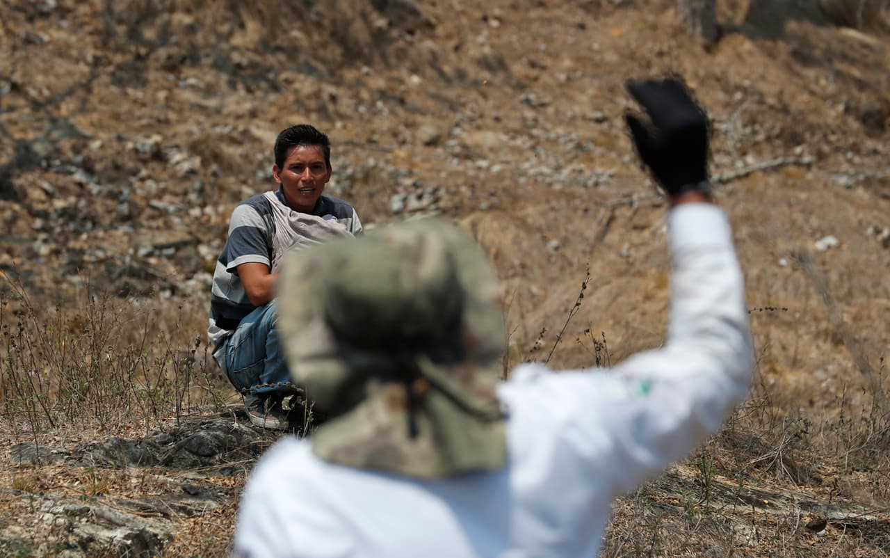 El hondureño Kevin Escobar, de 27 años, escucha a un agente de inmigración mexicano que trata de convencerlo de que se entregue. Luego pudo escapar de la redada.