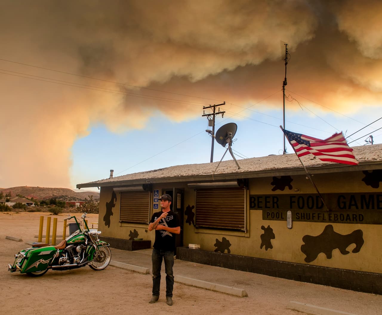 Uno de los evacuados a un motel de carretera por culpa del incendio 'Pilot' observa las columnas de humo.