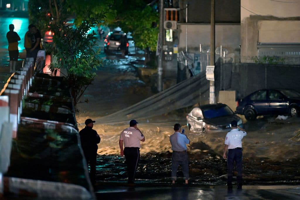 Funcionarios de la policía y otros servicios atendiendo una fuerte inundación en Puerto Vallarta tras el paso del huracán Roslyn.