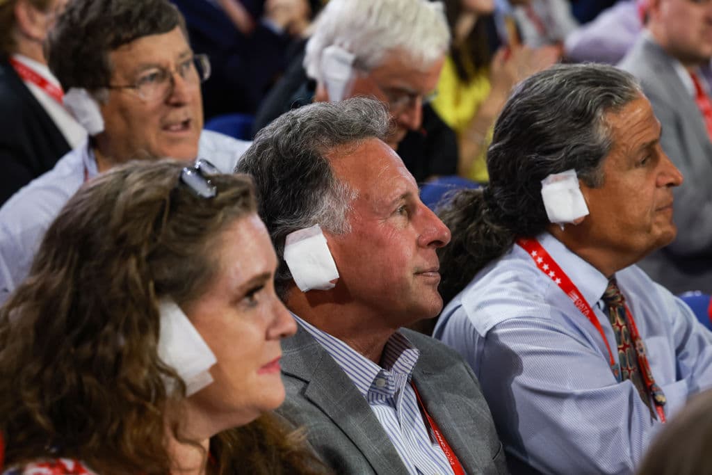 MILWAUKEE, WISCONSIN - JULY 17: People wear "bandages" on their ears as they watch on the third day of the Republican National Convention at the Fiserv Forum on July 17, 2024 in Milwaukee, Wisconsin. Delegates, politicians, and the Republican faithful are in Milwaukee for the annual convention, concluding with former President Donald Trump accepting his party's presidential nomination. The RNC takes place from July 15-18. (Photo by Joe Raedle/Getty Images)