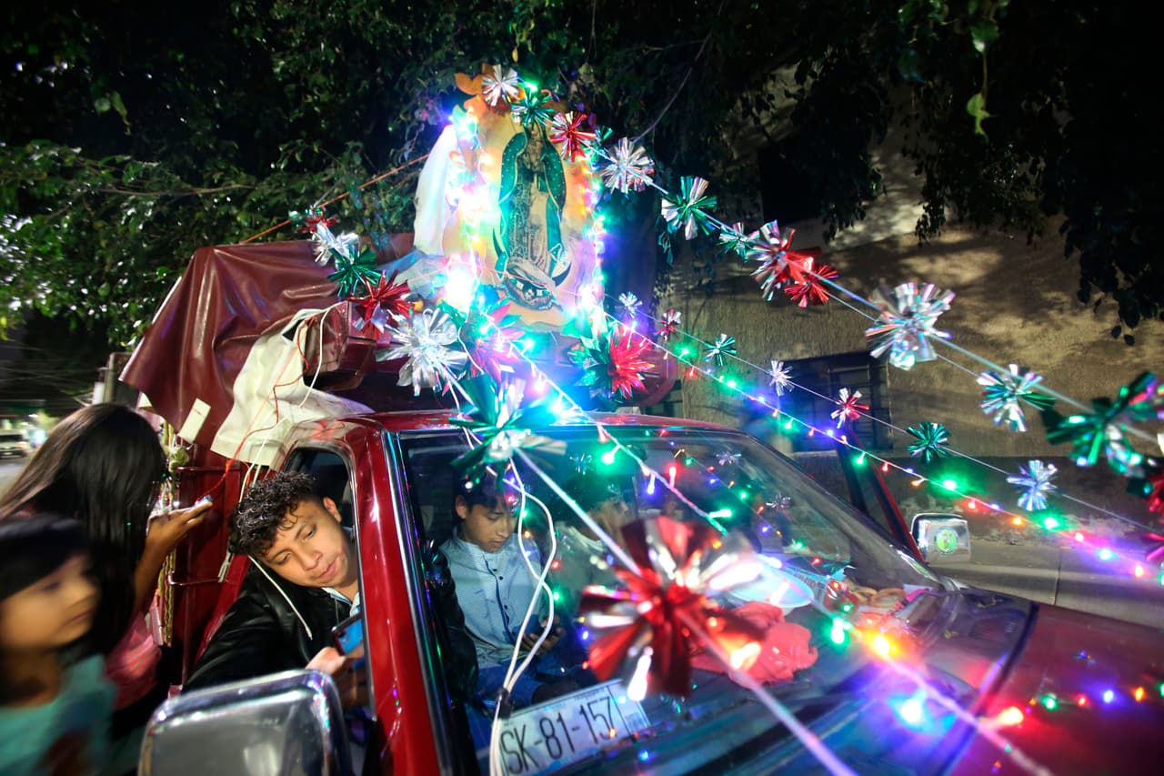 David Aca, de 17 años, se asoma desde el asiento del pasajero mientras se dirigen a la Basílica de Guadalupe. La familia viene de Puebla, un estado a unos 100 kilómetros de la Ciudad de México.