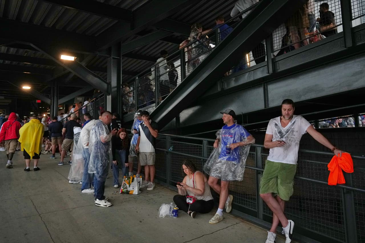 Unos aficionados aguardan en una zona cubierta del estadio mientras el mal tiempo interrumpe el partido del Grupo I de la Copa del Mundo de fútbol entre Francia e Irak en Filadelfia, el lunes 22 de junio de 2026.
