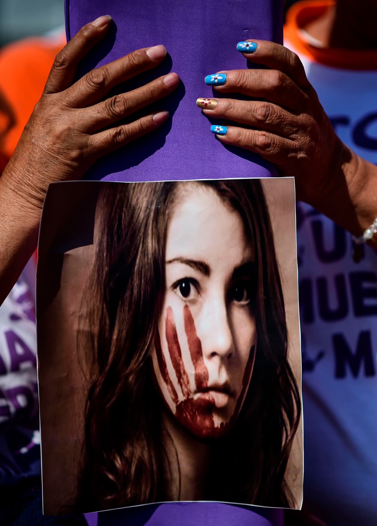 Mujeres marchan mostrando fotografías de víctimas de violencia en México.