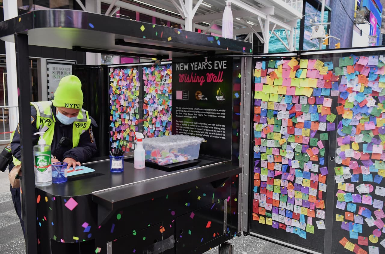 Un oficial de la policía de Nueva York (NYPD) escribe sus deseos en uno de los confetis que serán arrojados en el aire en Times Square. El evento será televisado a todo el mundo, pese a la falta de público forzada por el coronavirus.