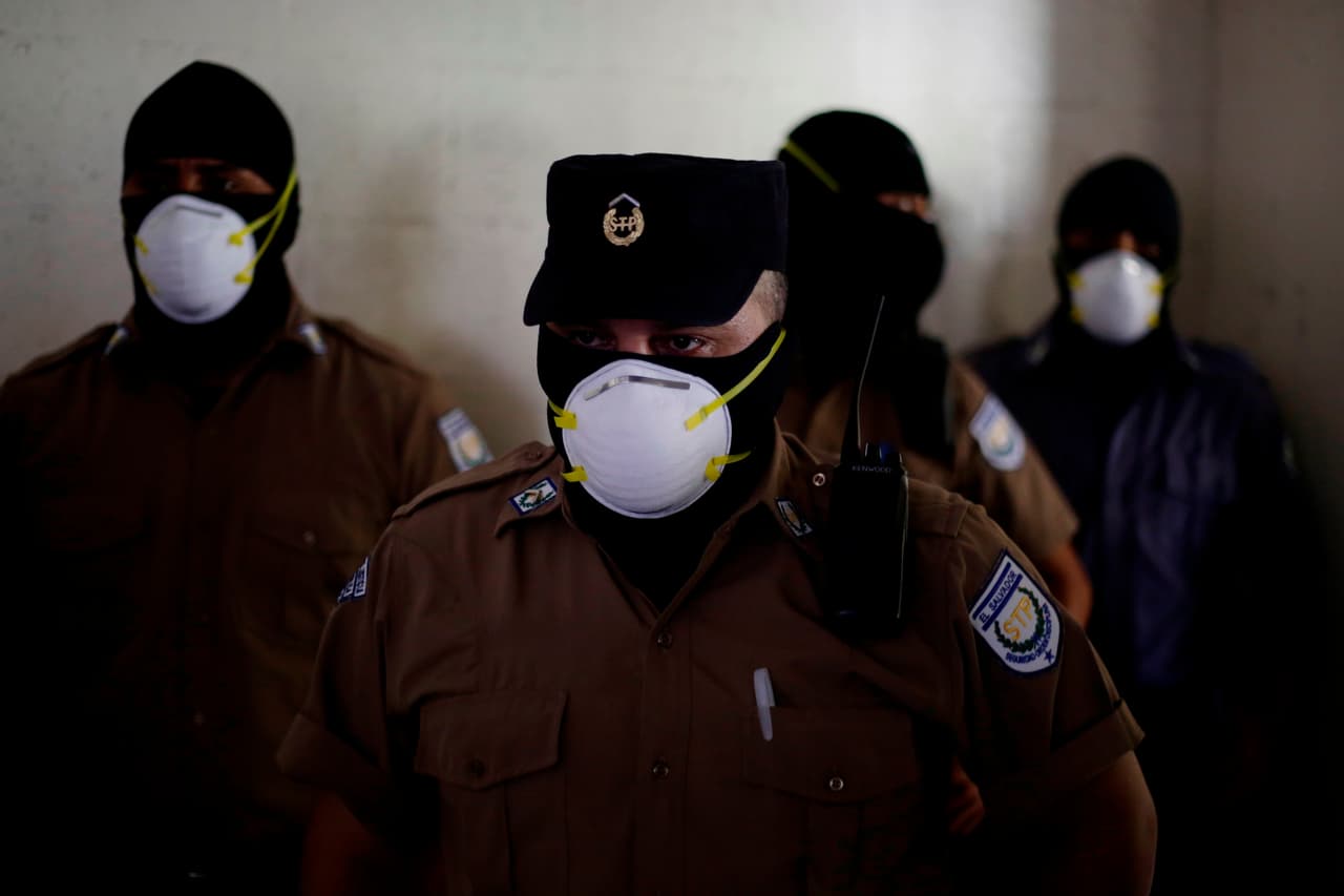 Los guardias de la prisión de Izalco, protegidos del coronavirus con mascarillas, el 27 de abril.
<a href="https://www.univision.com/noticias/el-salvador-mezcla-reos-de-pandillas-rivales-en-las-celdas-y-cierra-carceles-tras-registrar-29-asesinatos-en-un-dia-video">El Gobierno de Bukele decidió mezclar a los miembros de pandillas rivales en las celdas</a> en las diferentes prisiones del país, en las que se encontraban separados por grupos.