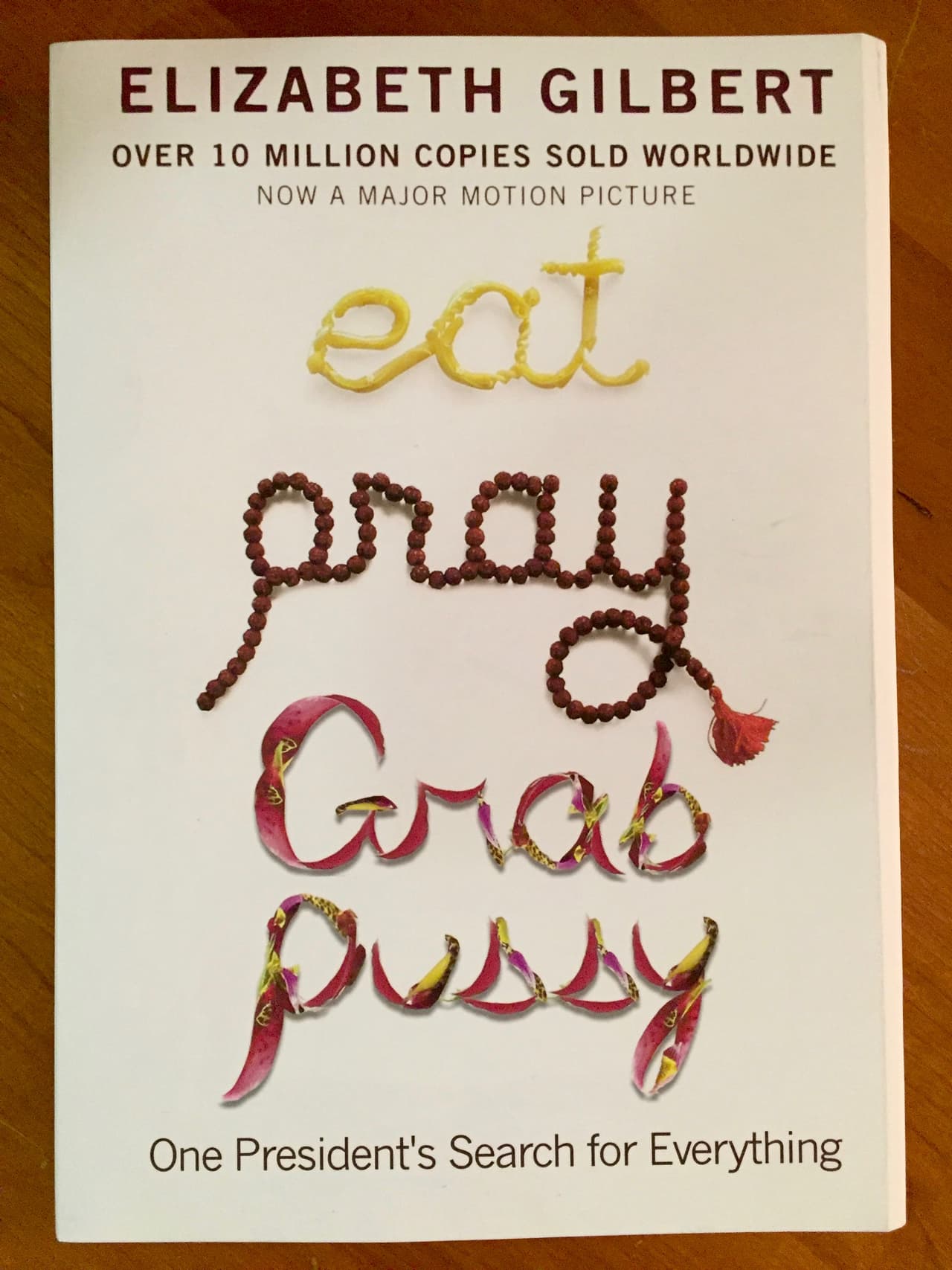 En esta carátula el nombre de la autora se mantiene real. Elizabeth Gilbert efectivamente escribió el emblemático libro
<b>'Comer, rezar, amar' </b>que fue cambiado por
<b>'Comer, rezar, manosear'</b> haciendo alusión a aquellas escandalosas palabras que profirió Donald Trump con Billy Bush en aquel autobus en 2005 que se revelaron unos días antes del segundo debate presidencial.