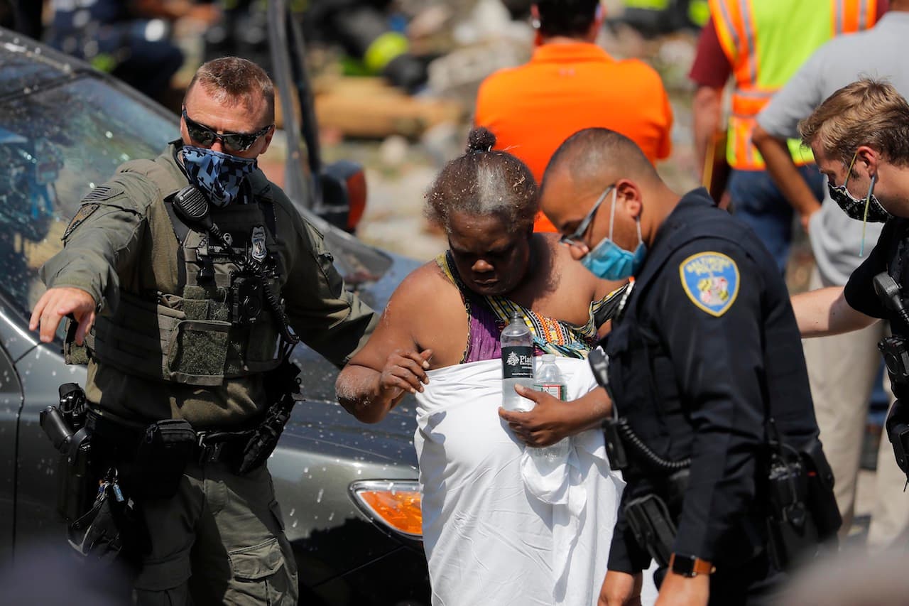 Las autoridades guían a una persona después de una explosión en Baltimore el lunes 10 de agosto de 2020.