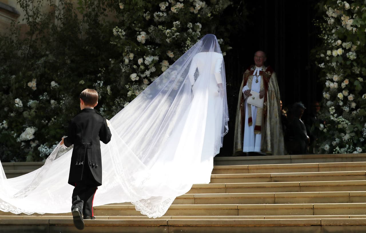 La duquesa de Sussex subió la escalinata de la capilla escoltada por dos pajes. Su vestido fue diseñado por Clare Waigh Keller para Givenchy y tenía la orilla bordada con flores que representan a las 53 colonias de la Commonwealth.