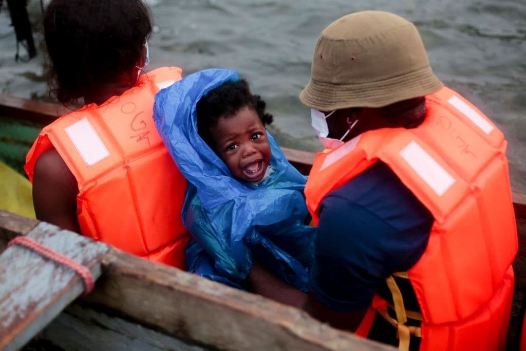 Un migrante y un bebé son transportados desde la aldea de Bajo Chiquito a la Estación de Recepción de Migrantes en Lajas Blancas, provincia de Darién, en Panamá el 23 de agosto de 2021.