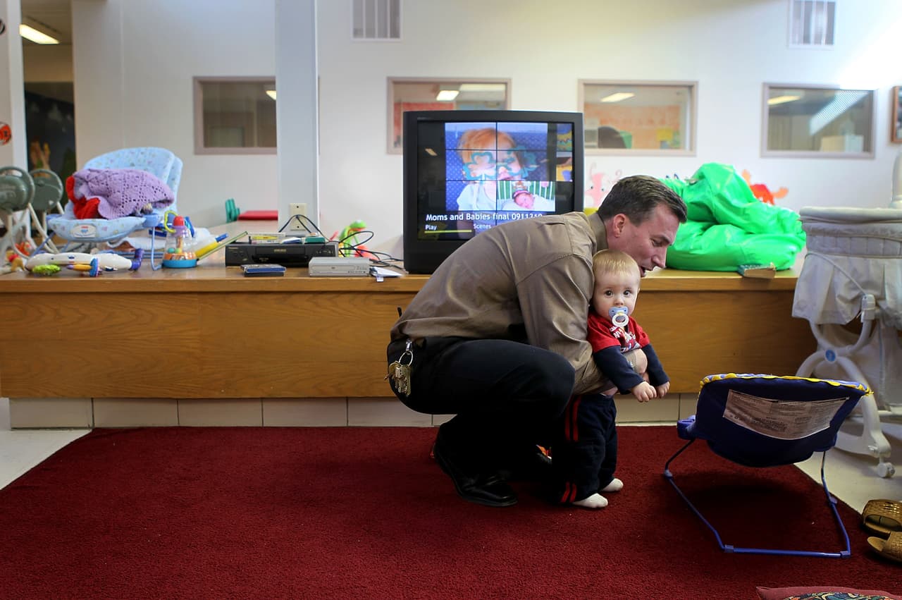 El oficial John MacIntosh sostiene a un bebé.