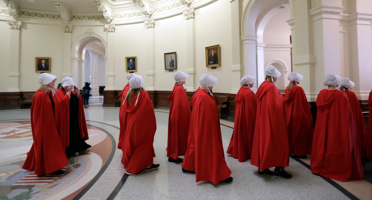 Activists dressed as characters from "The Handmaid's Tale" leave the Texas Capitol Rotunda as they protest SB8, a bill that would require health care facilities, including hospitals and abortion clinics, to bury or cremate any fetal remains whether from abortion, miscarriage or stillbirth, and they would be banned from donating aborted fetal tissue to medical researchers, Tuesday, May 23, 2017, in Austin. (AP Photo/Eric Gay)