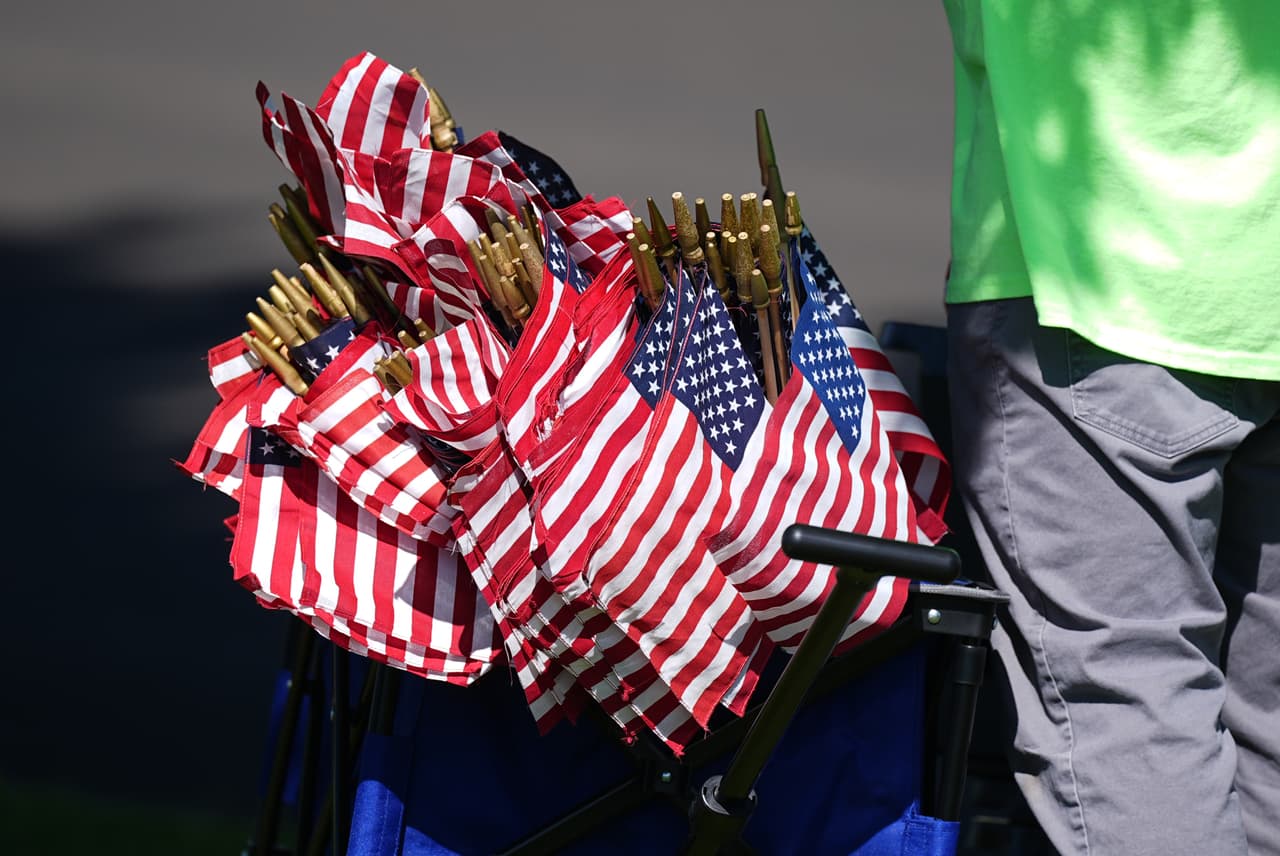Banderas estadounidenses reposan en un contenedor a la espera de ser colocadas en las tumbas de veteranos militares en el Cementerio Nacional de Fort Logan, al suroeste de Denver, el domingo 24 de mayo de 2026, para conmemorar el Día de los Caídos. (Foto AP/David Zalubowski)