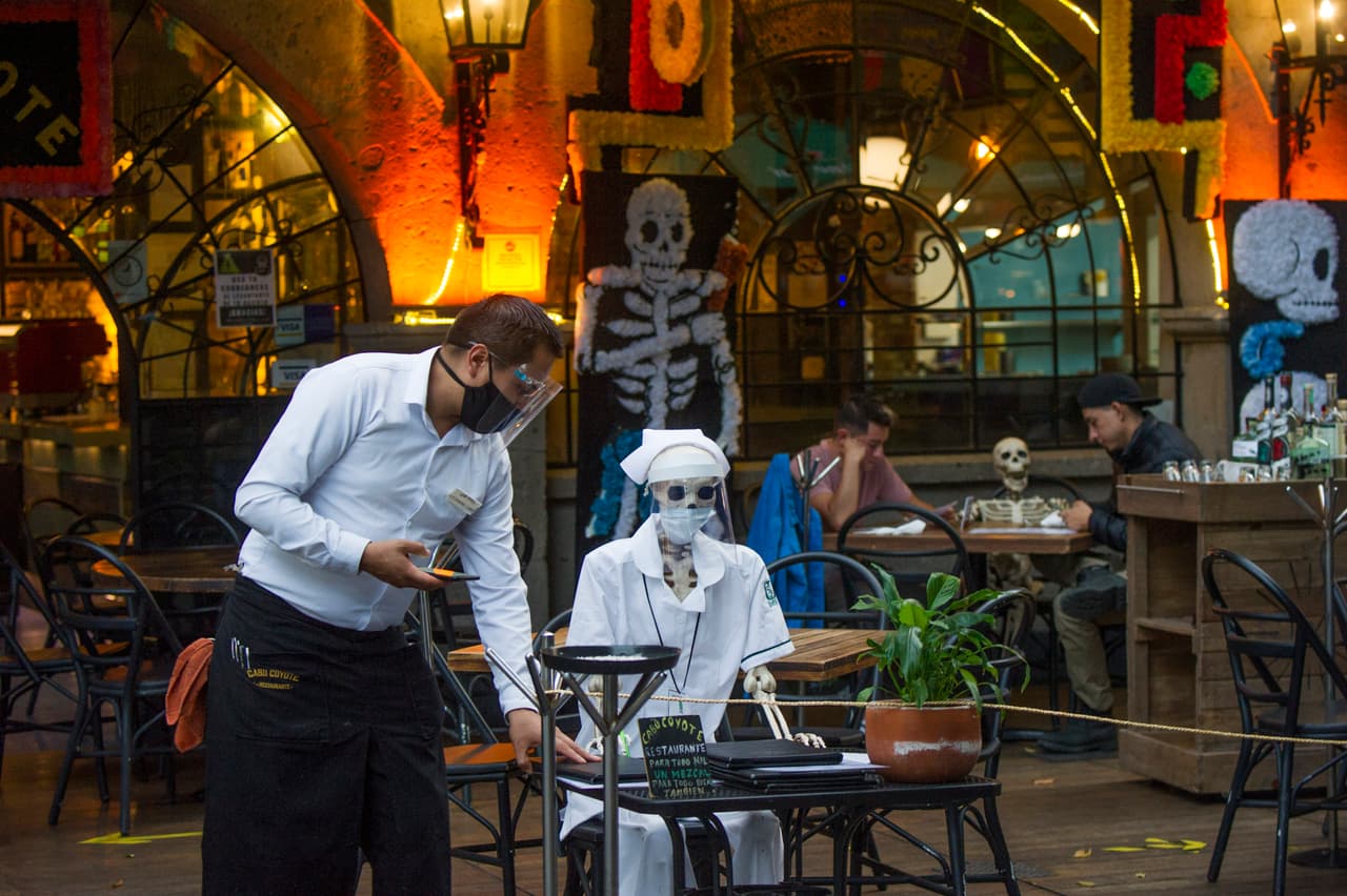 Vista de la llamada Calaca (figura de calavera o esqueleto) comúnmente utilizada para decoración durante el Día de Muertos mexicano, se utiliza para mantener medidas de distanciamiento social, en un restaurante de Ciudad de México