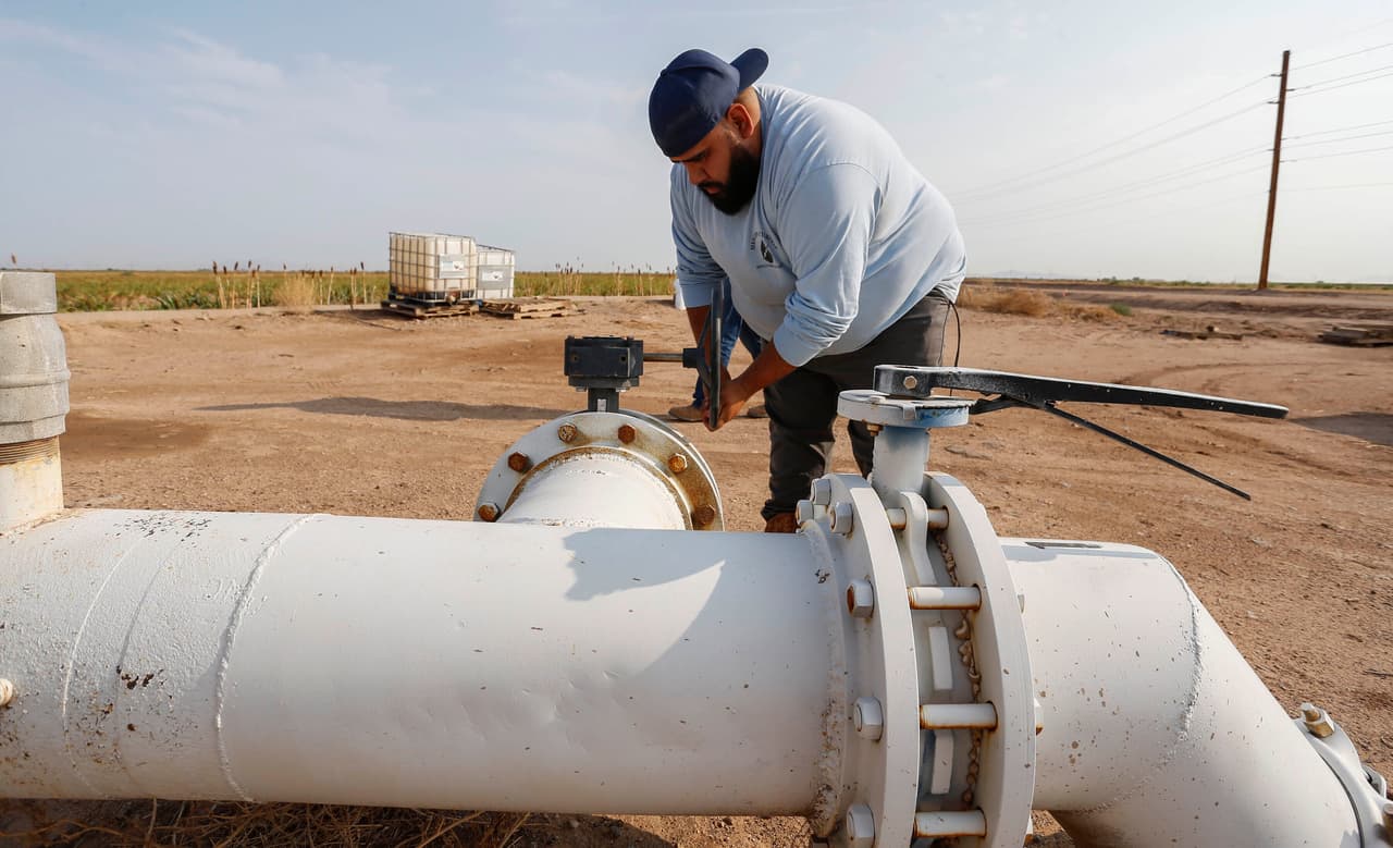 Un zanjero (o "ditch-river) trabaja en el distrito de Maricopa-Stanfield. Las consecuencias de los recortes, de acuerdo con expertos consultados por la agencia AP, causarán una reacción en cadena. Las lecherías dependen en gran medida de las granjas locales para la alimentación de sus animales y tendrán que gastar más para obtener suministro, lo que afectará la economía local.
