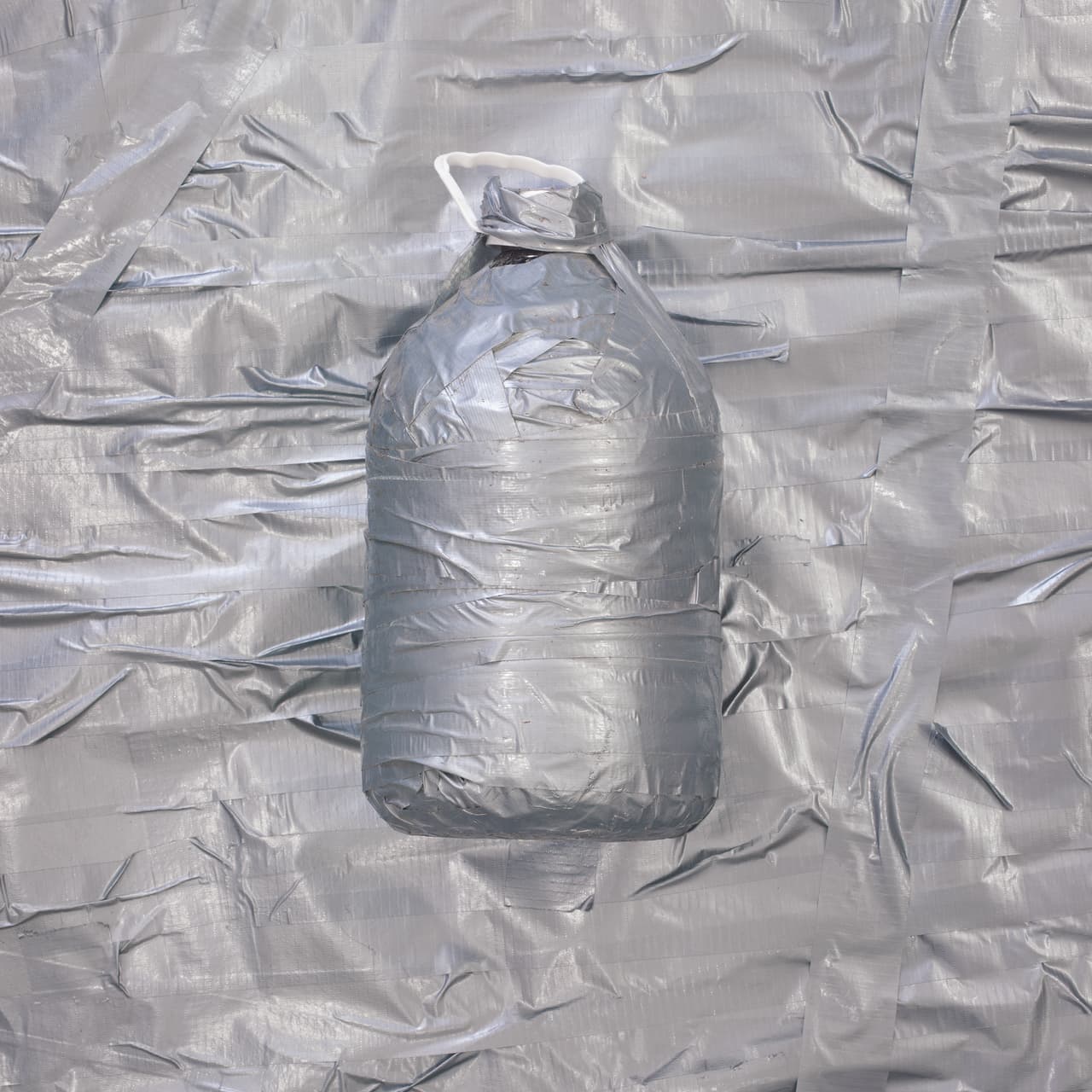 “Desde que Donald Trump dijo en la campaña que los mexicanos son violadores y criminales entendí que su estrategia pretendía crear miedo. Lamentablemente una buena parte del país cree en las palabras de Trump y aceptaron ese discurso”, agregó el artista.
<b>'Botella de agua con cinta adhesiva'</b>, el título de esta imagen.