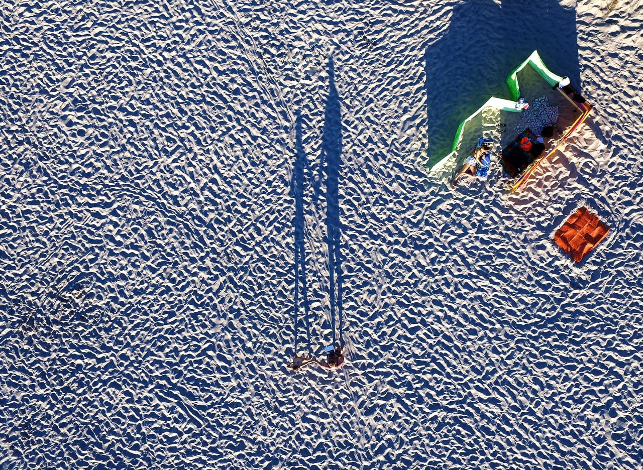 Turistas caminan sobre la arena de Miedzydroje, playa en la costa del Mar Báltico, Polonia.