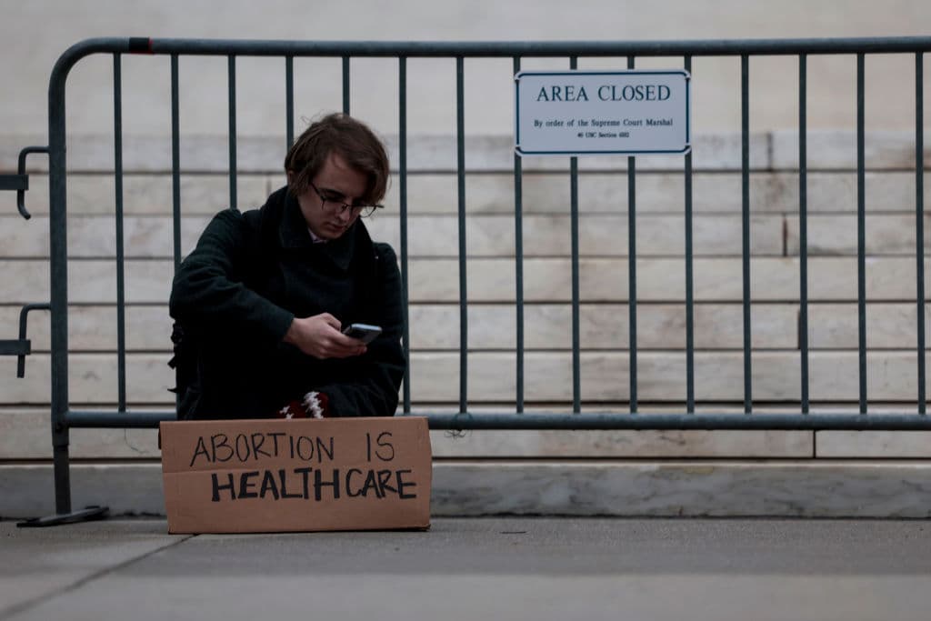 "El aborto es sanidad", se lee en el letrero que descansa en los pies de un chico frente a la Suprema Corte de Justicia de Estados Unidos en Washington.