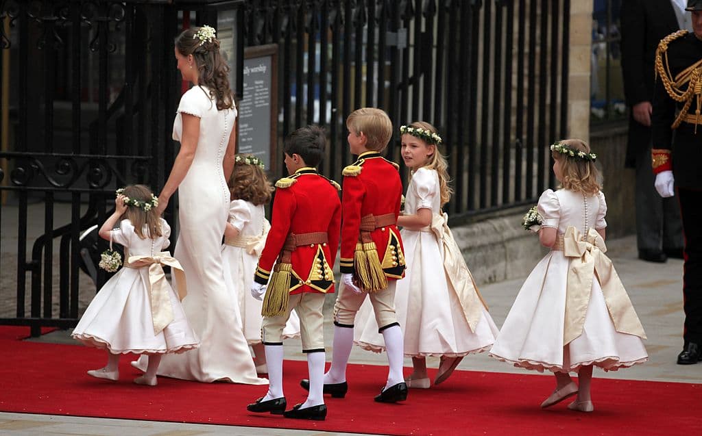 A veces el protocolo marca otras normas, como sucede en el caso de ocasiones especiales. En la boda del príncipe William y Kate Middleton en el 2011, los invitados más jóvenes que hicieron de pajes, familiares e hijos de amigos, llevaron unos conjuntos inspirados en los uniformes de los guardias británicos, un estilo anclado en 1820.
<b><a href="http://www.univision.com/personas-pippa-middleton">Pippa Middleton</a></b>, hermana de Kate, fue la dama de honor y condujo a los niños en la entrada de la abadía de Westminster en Londres.