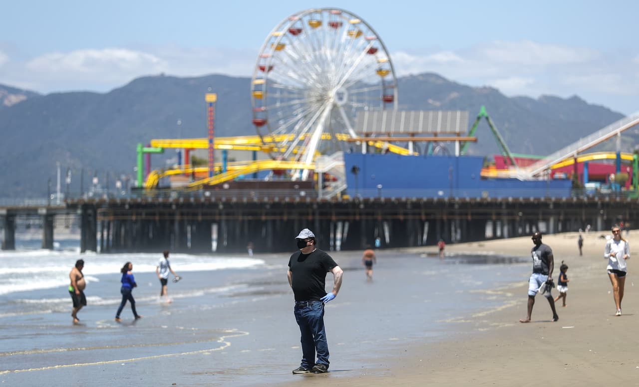 Algunas personas visitan las playas de Santa Mónica, California, pero siguiendo las nomatividades sobre el distanciamiento social y el uso de tapabocas, tal como lo han ordenado las autoridades del estado.