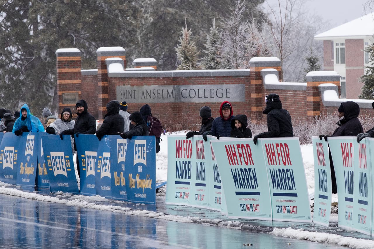 Partidarios de los candidatos Pete Buttigieg, exalcalde de South Bend, Indiana, y Elizabeth Warren, senadora por Massachusetts, congregados fuera de Saint Anselm College, sede del debate de esta noche.