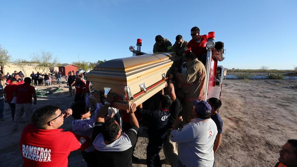 Family and friends carry a coffin with the body of a dead firefighter in a confrontation with suspected drug traffickers in Villa Unión, Coahuila, Mexico, on December 3, 2019.