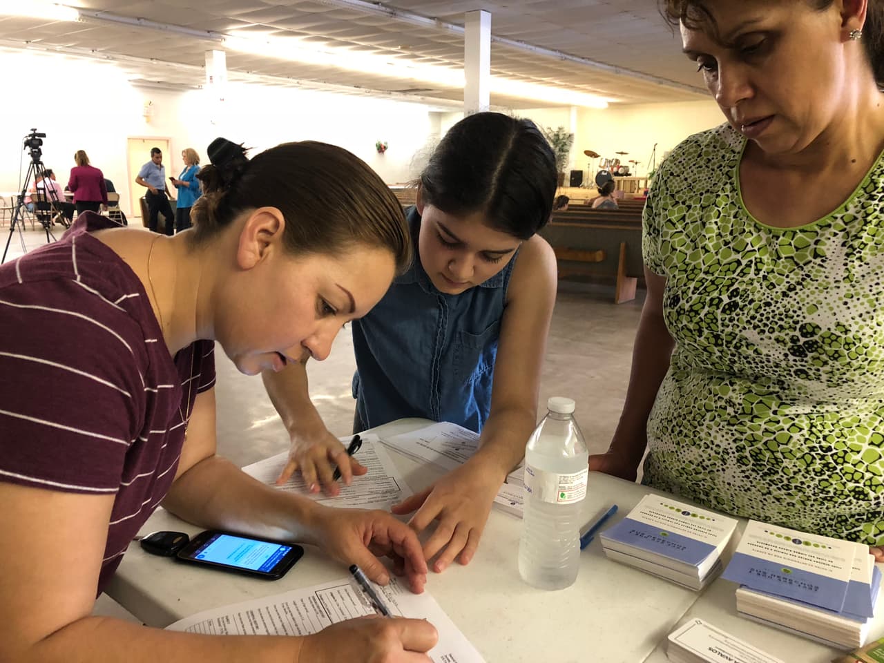 Laura García, su hija de 16 años y su pariente Silvia Peña completaban formularios en una mesa con material informativo de varias organizaciones comunitarias.