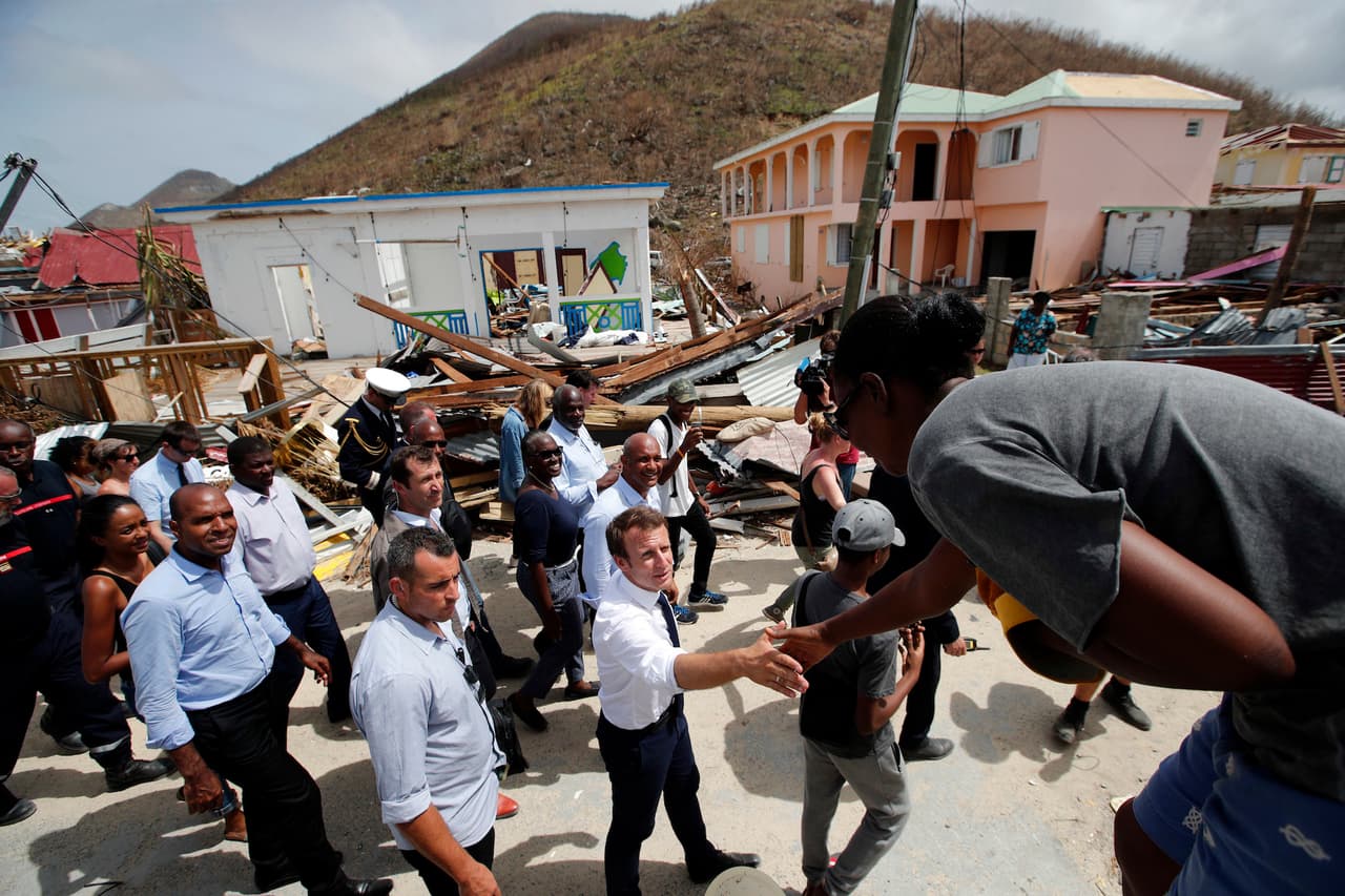 El presidente de Francia, Emmanuel Macron, estrecha la mano de residentes durante su visita a la isla francesa de San Martín, en el Caribe, el martes 12 de septiembre de 2017. Macron se encuentra en la isla que comparten los gobiernos de Francia y Holanda, en donde 10 personas murieron, en la parte francesa, debido al paso del huracán Irma. (AP Foto/Christophe Ena, Pool)