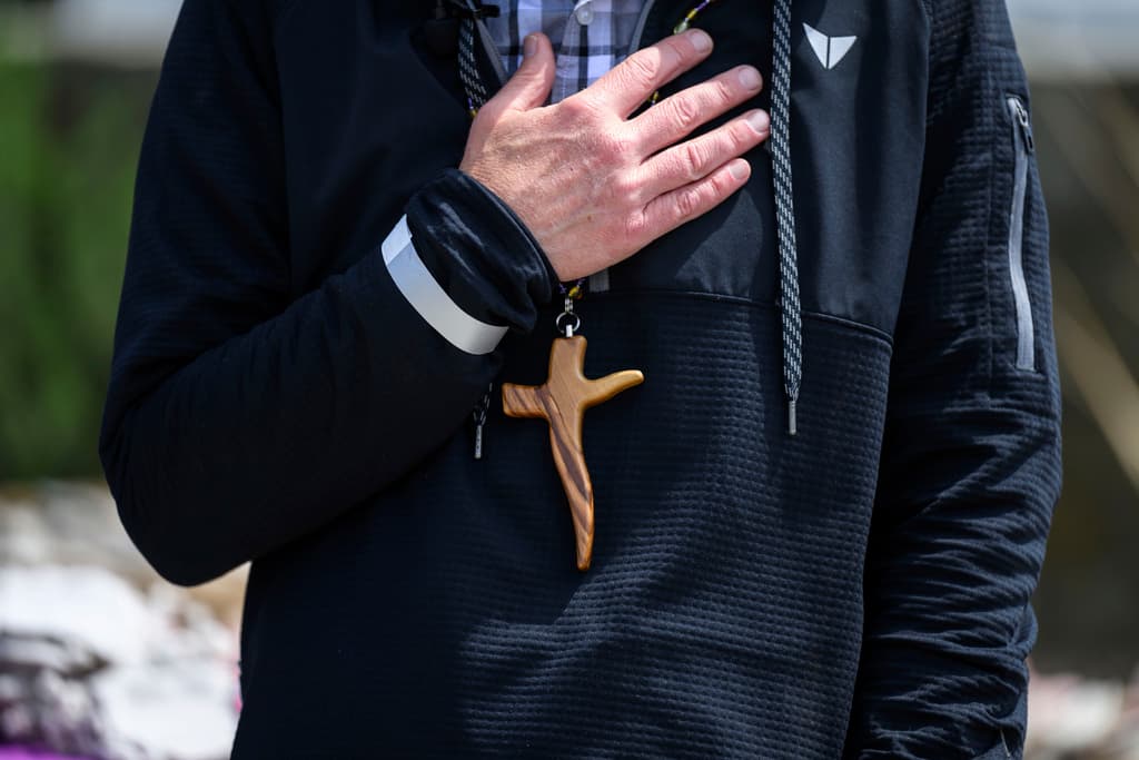 <b>La cruz como símbolo de resiliencia</b>: Pastor Shaver porta una cruz de madera, recordando a la congregación que, aunque la iglesia se quemó, el espíritu de la comunidad sigue vivo.