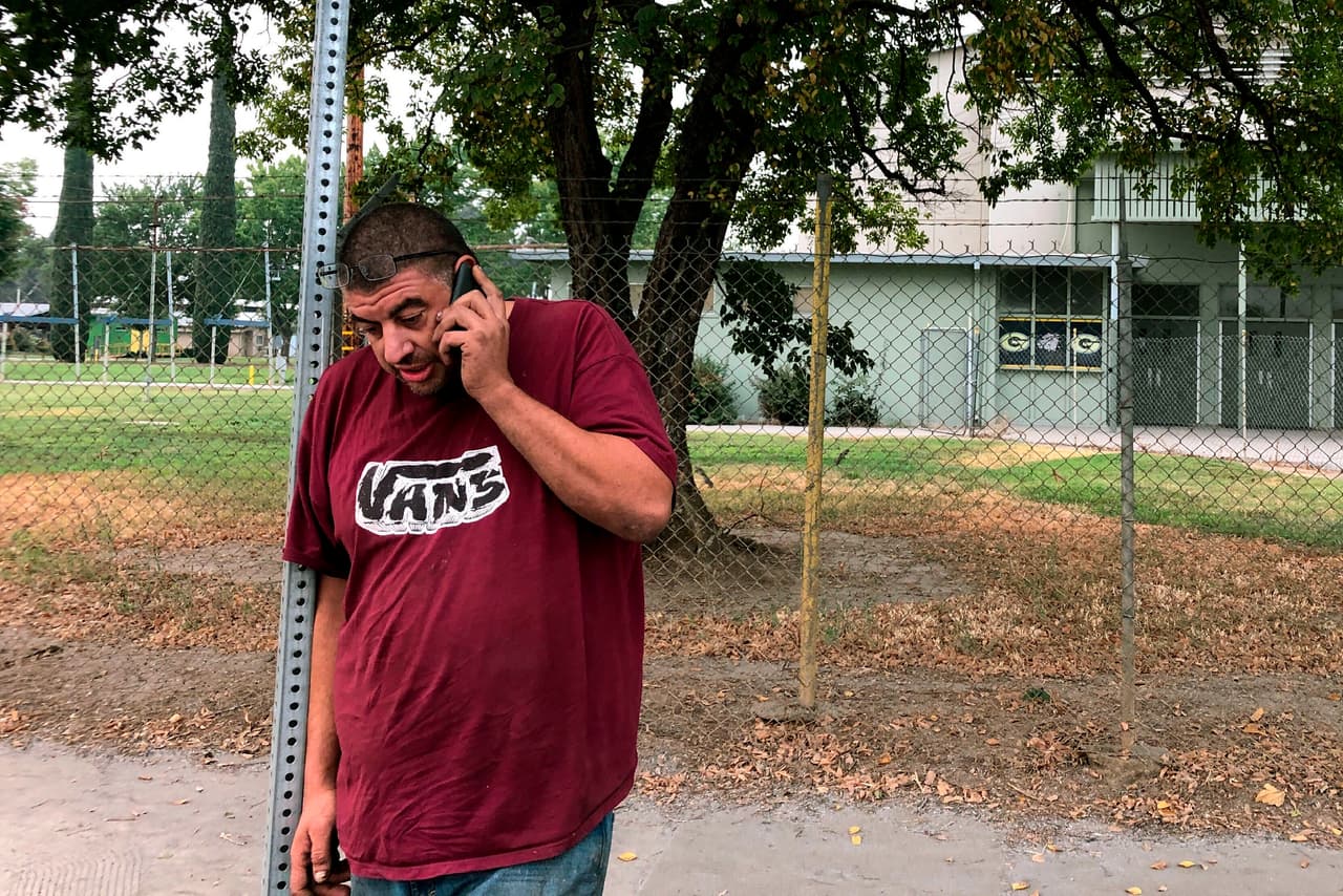 Douglas Johnsrude habla por teléfono en un centro de evacuación de emergencia en Gridley, California. Johnsrude evacuó su casa en Feather Falls
<b>y cree que perdió su casa en el incendio, pero no está seguro.</b> La situación no es nueva para él, ya que había perdido su antiguo hogar en el Ponderosa Fire en 2017.
<br>