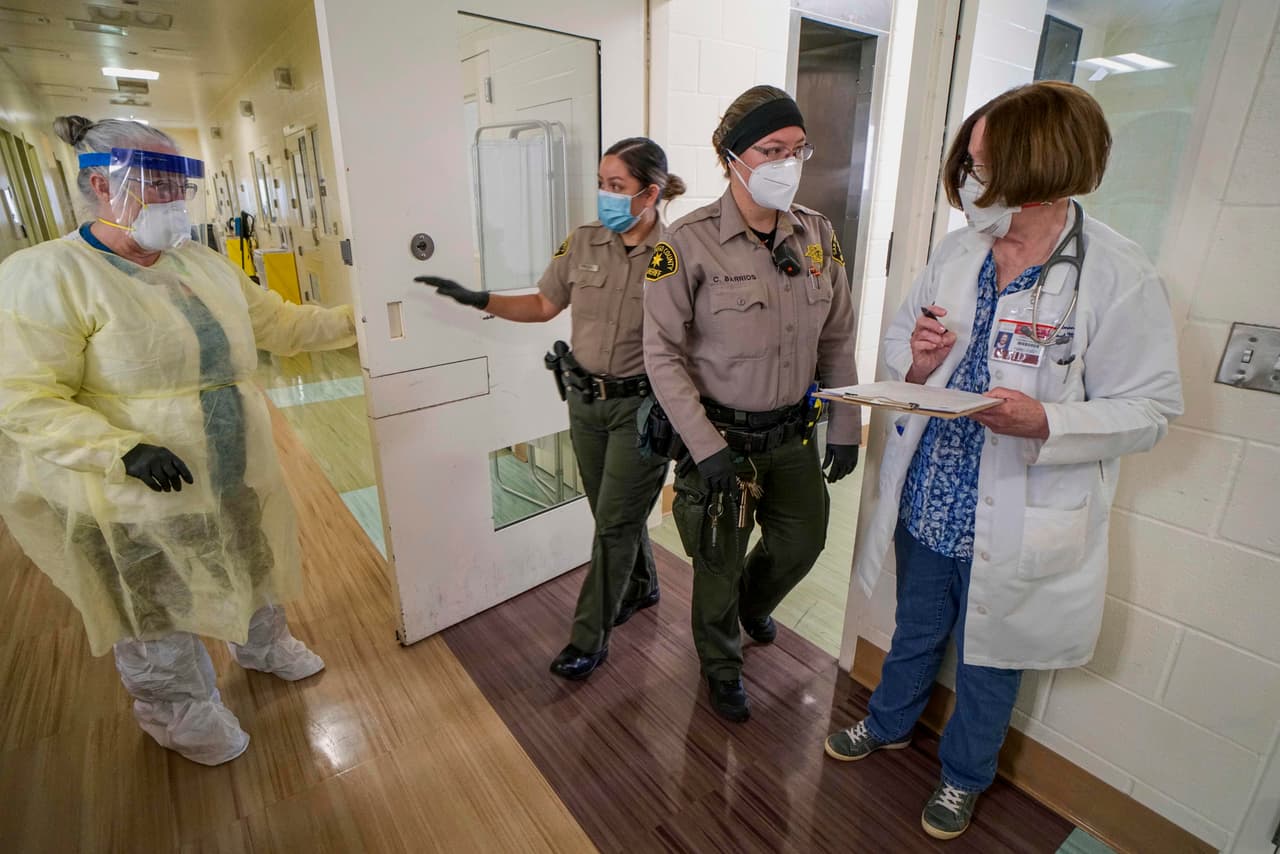Oficiales de policía acompañadas de una enfermera dan medicación a una reclusa en el centro de detención de mujeres Las Colinasm en Santee, California, el 22 de abril.