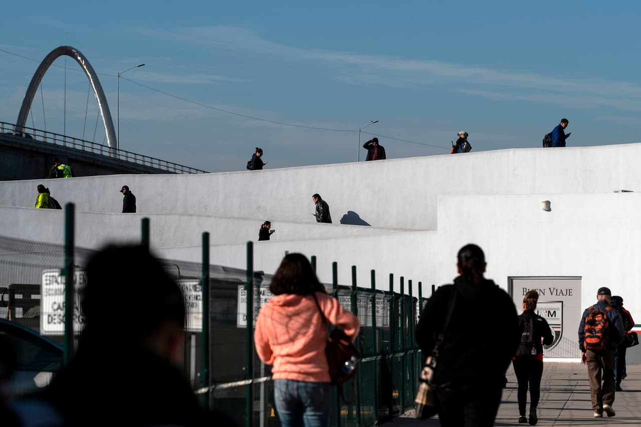 Personas caminan en el cruce peatonal El Chaparral en la frontera Tijuana-San Diego el 13 de marzo de 2020.