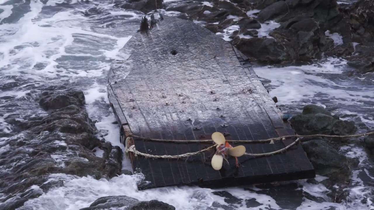 Washed up and flipped over, the wooden ghost ship with propeller facing up.
