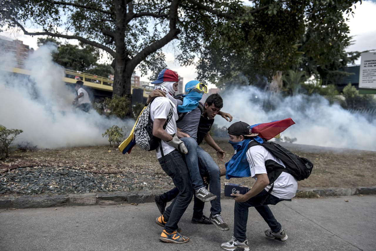 Un grupo de manifestantes auxilia a un compañero herido durante las protestas.