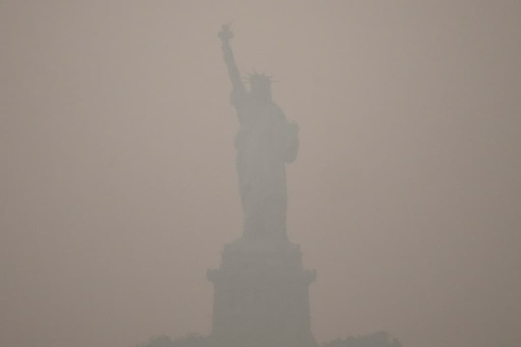 La Estatua de la Libertad se alza al atardecer mientras el humo de los incendios forestales cubre el cielo, el jueves 16 de julio de 2026, en el distrito de Brooklyn, Nueva York. (Foto AP/Yuki Iwamura)