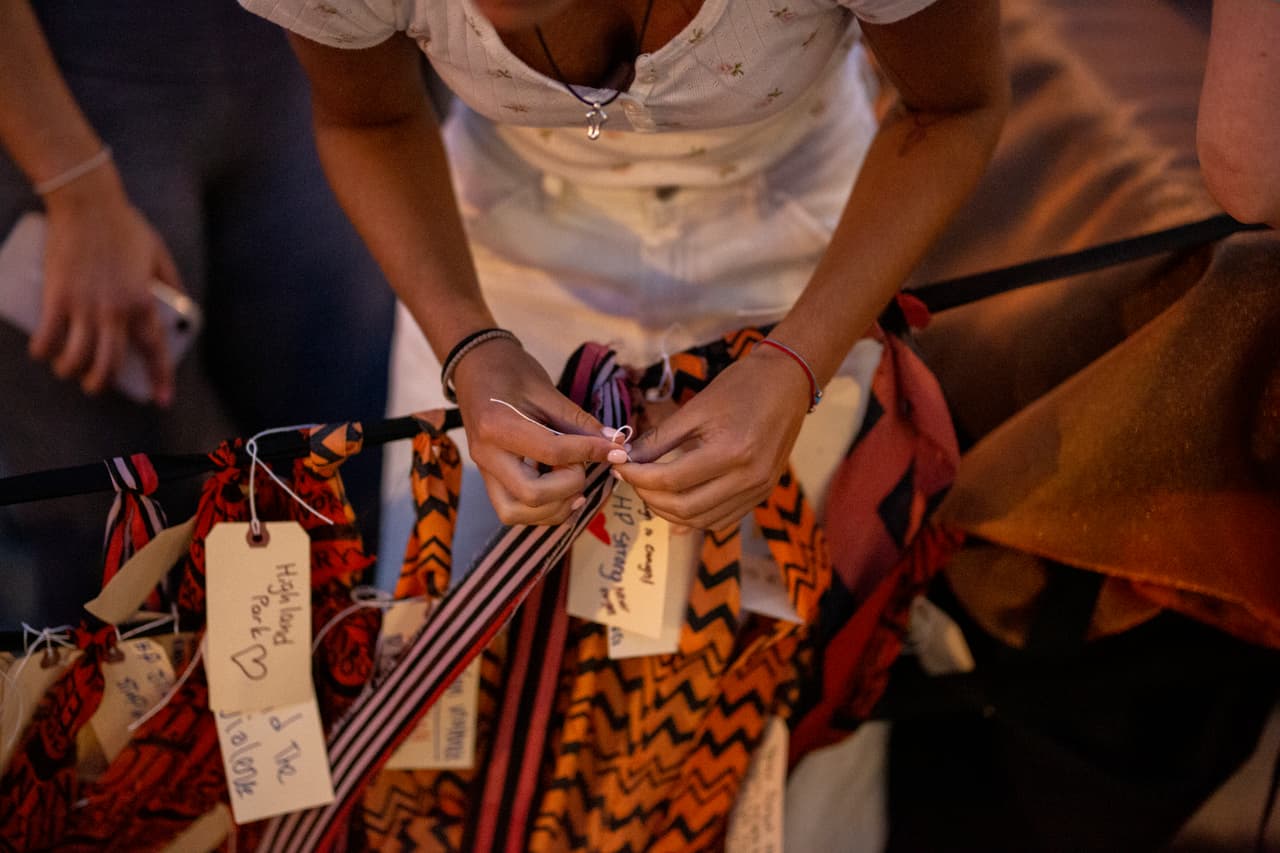 La gente añade tiras de tela con nombres y frases en memoria de las víctimas en la vigilia cerca del lugar del tiroteo en el desfile del 4 de julio, en Highland Park.