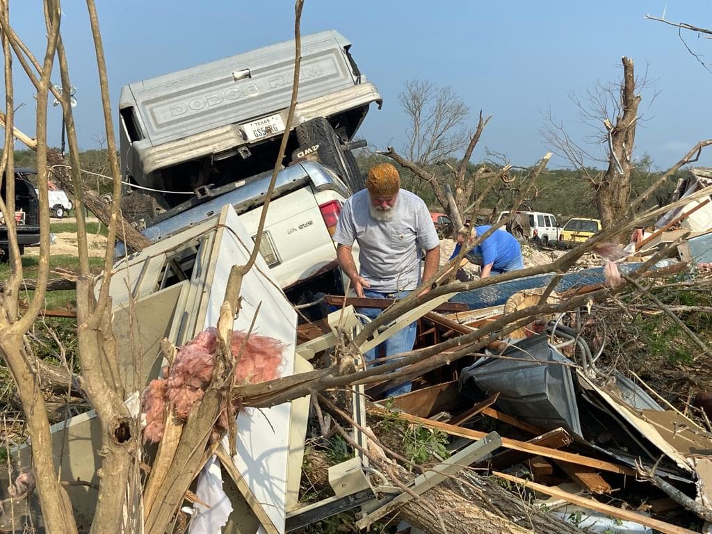 Un residente busca sus pertenencias de los escombros.